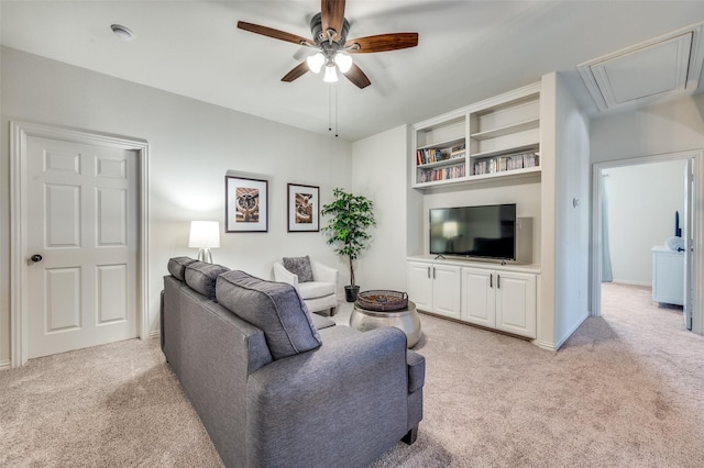 living room featuring light colored carpet, attic access, and ceiling fan