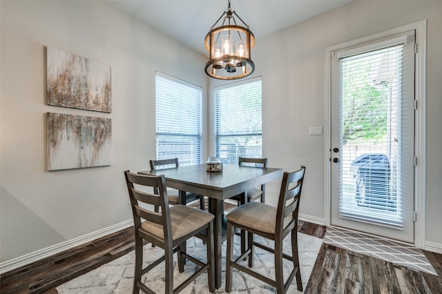 dining room with baseboards, a chandelier, and dark wood-type flooring