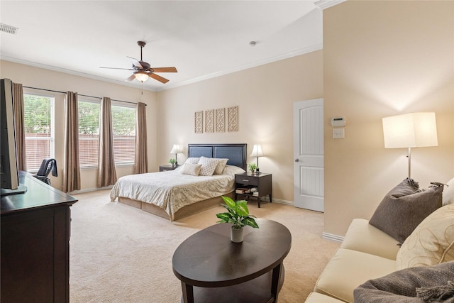 bedroom with a ceiling fan, visible vents, light colored carpet, baseboards, and ornamental molding