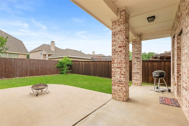 view of patio featuring a fenced backyard and a fire pit
