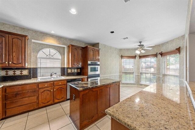 2806 Glenwick Ct, Richardson, TX 75082 - kitchen featuring stainless steel appliances, a center island, healthy amount of natural light, light tile patterned floors, and wallpapered walls