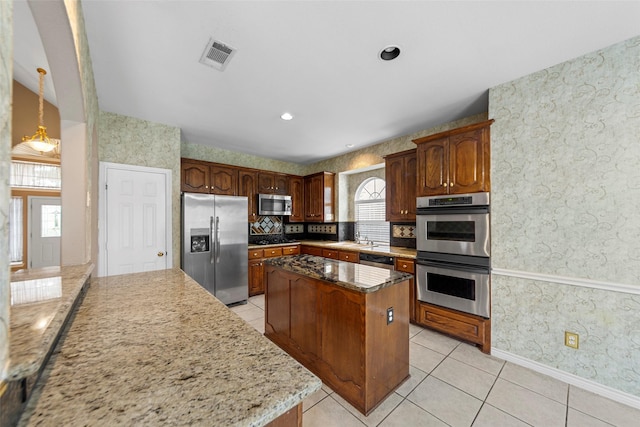 2806 Glenwick Ct, Richardson, TX 75082 - kitchen with stainless steel appliances, wallpapered walls, a center island, light tile patterned floors, and baseboards