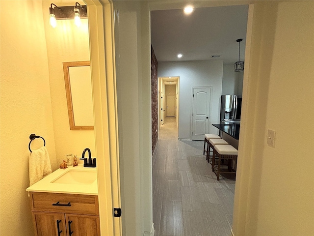 bathroom featuring recessed lighting, wood finished floors, and vanity