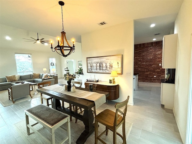 dining room featuring a notable chandelier, recessed lighting, brick wall, and visible vents