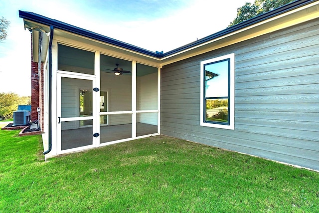 rear view of property with a lawn, central AC, and a sunroom