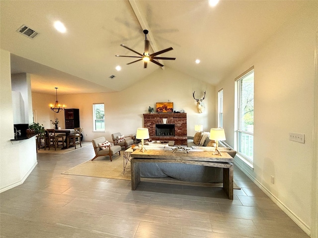 living area featuring visible vents, a brick fireplace, ceiling fan with notable chandelier, vaulted ceiling with beams, and recessed lighting