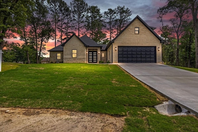 traditional-style home featuring concrete driveway, an attached garage, and a front lawn