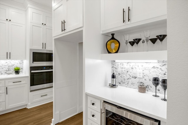 kitchen featuring wine cooler, white cabinets, backsplash, and oven