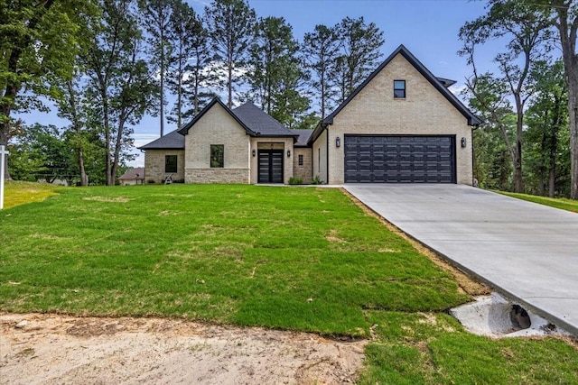 view of front of property with concrete driveway, brick siding, french doors, and a front yard