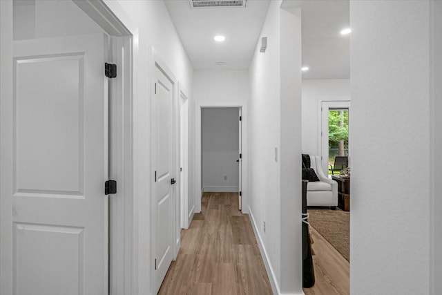 corridor with baseboards, recessed lighting, wood finished floors, and visible vents