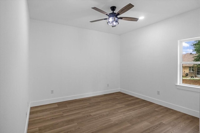 unfurnished room featuring baseboards, ceiling fan, and wood finished floors