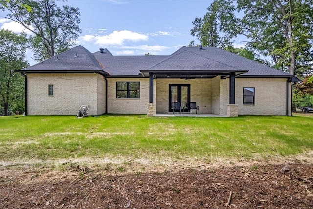 back of property featuring roof with shingles, a ceiling fan, a lawn, and a patio area