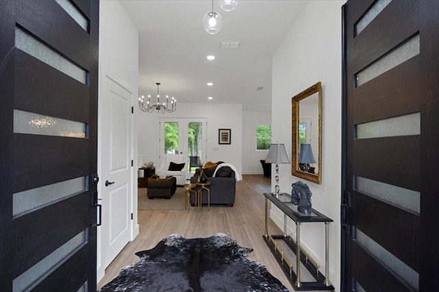 entryway featuring light wood-style floors, recessed lighting, a notable chandelier, and visible vents