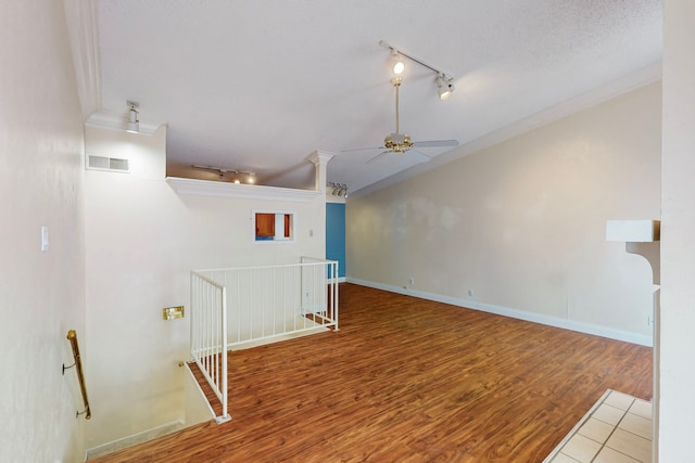 interior space featuring a ceiling fan, visible vents, track lighting, and wood finished floors