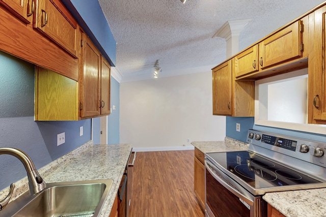 kitchen with a textured ceiling, brown cabinets, stainless steel electric stove, a sink, and dark wood finished floors