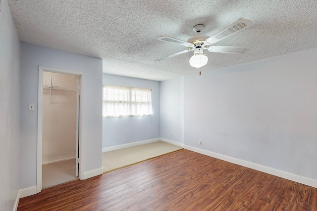 spare room with baseboards, a ceiling fan, a textured ceiling, and wood finished floors