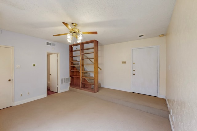 unfurnished room featuring visible vents, carpet flooring, baseboards, and ceiling fan
