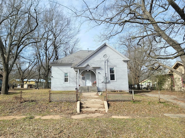 view of front of property featuring a fenced front yard and a shingled roof