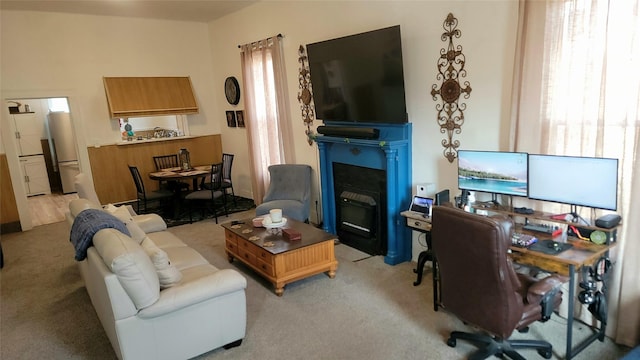 living room featuring a fireplace with flush hearth and light carpet