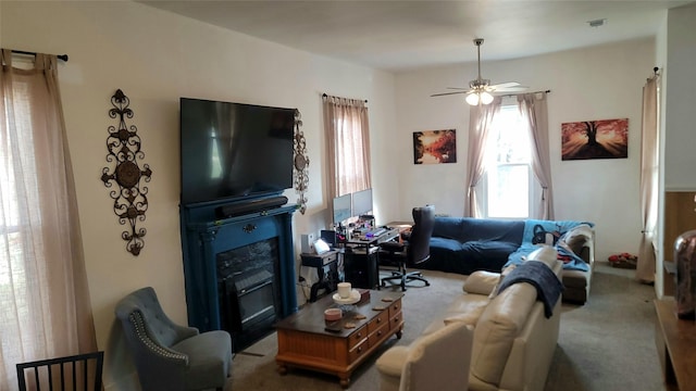 carpeted living room with a glass covered fireplace, ceiling fan, and visible vents