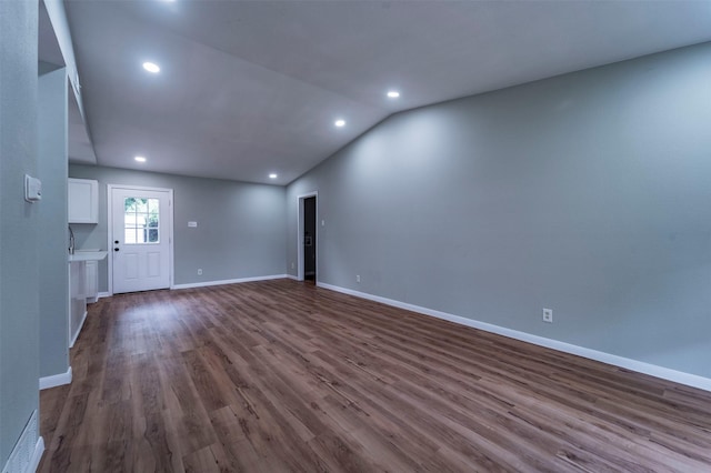 unfurnished living room with dark wood-type flooring, recessed lighting, and vaulted ceiling