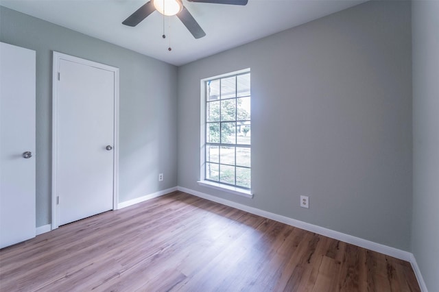 unfurnished bedroom with a ceiling fan, baseboards, and wood finished floors