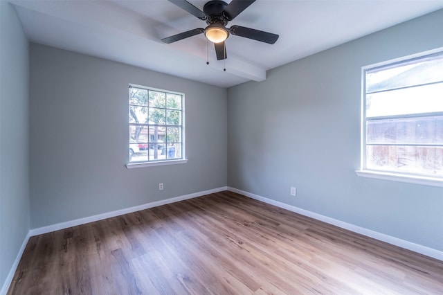 spare room with baseboards, ceiling fan, and wood finished floors