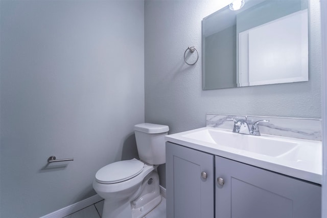 bathroom featuring vanity, baseboards, and toilet