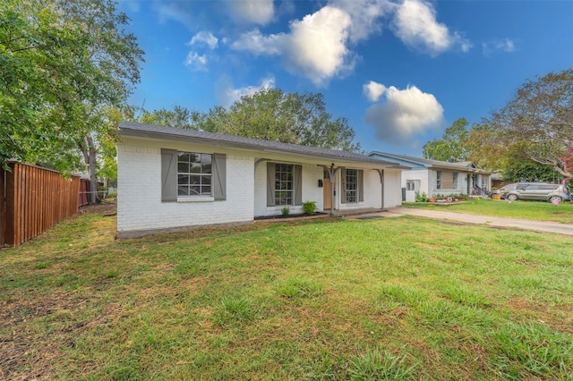 ranch-style house with brick siding, fence, and a front yard
