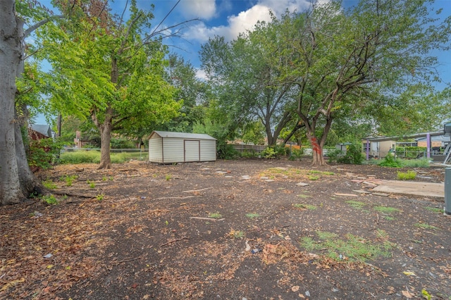 view of yard with fence, an outdoor structure, and a shed