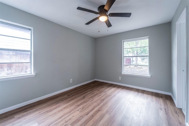 empty room with baseboards, ceiling fan, and light wood-style floors