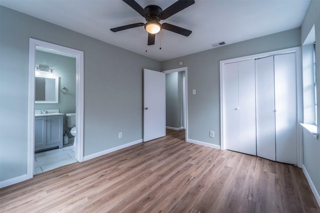 unfurnished bedroom featuring baseboards, a closet, light wood-type flooring, and visible vents