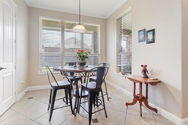 dining area with plenty of natural light, ornamental molding, baseboards, and light tile patterned flooring
