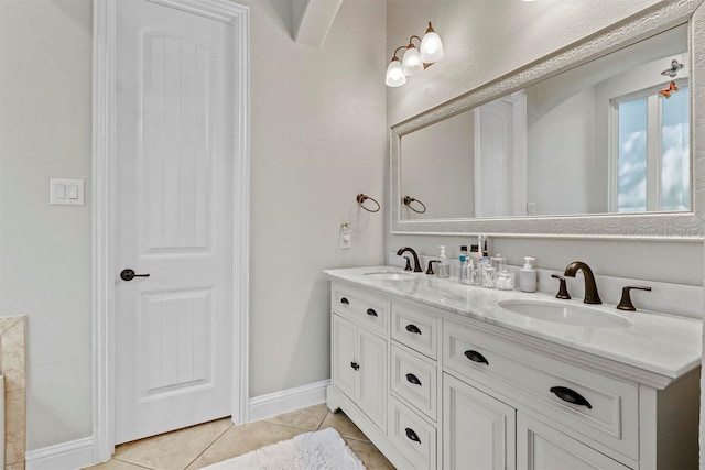 full bathroom featuring a sink, tile patterned floors, baseboards, and double vanity