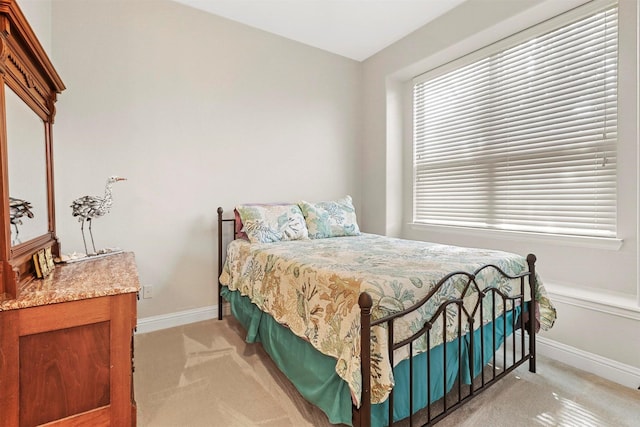 bedroom with baseboards and light carpet
