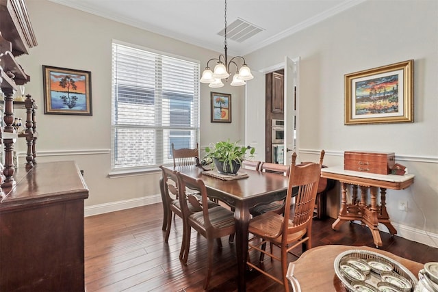 dining room with baseboards, dark wood-style flooring, crown molding, and a notable chandelier