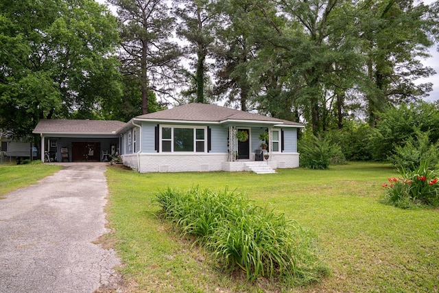 view of front facade featuring a shingled roof, an attached carport, a front lawn, and aphalt driveway