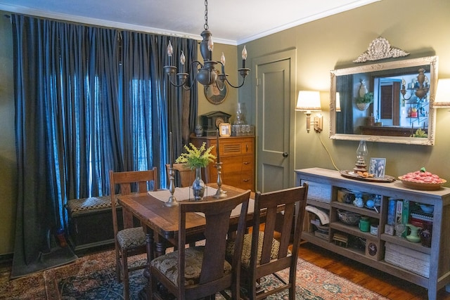 dining space featuring crown molding, an inviting chandelier, and wood finished floors
