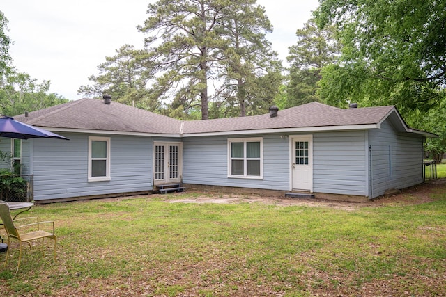 back of house featuring roof with shingles, a yard, and french doors