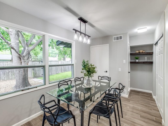 dining room featuring visible vents, baseboards, and light wood finished floors
