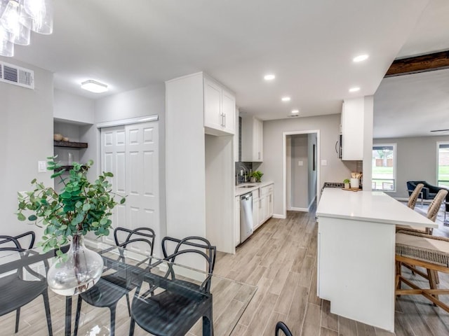 kitchen featuring visible vents, recessed lighting, light countertops, white cabinets, and stainless steel appliances