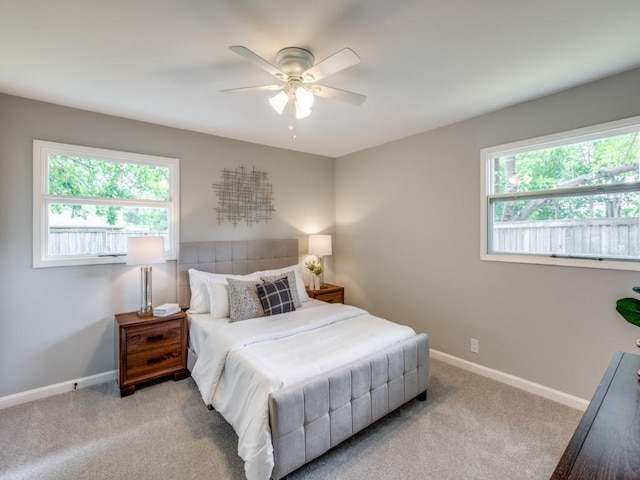 carpeted bedroom with a ceiling fan and baseboards
