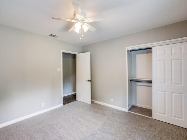 unfurnished bedroom with carpet flooring, baseboards, visible vents, and a closet
