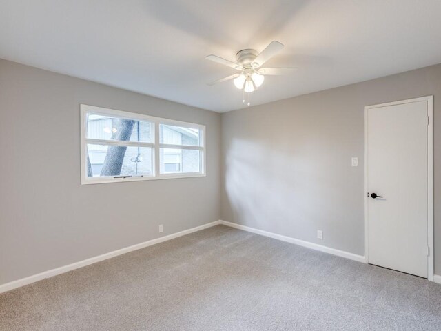 unfurnished room featuring light colored carpet, baseboards, and ceiling fan