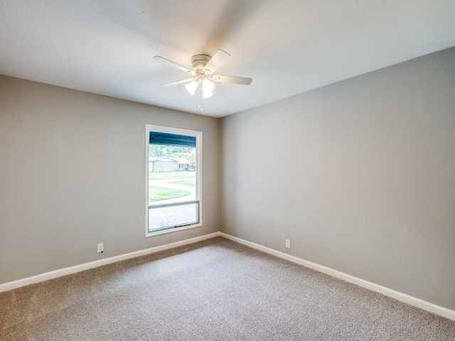 carpeted spare room with baseboards and ceiling fan
