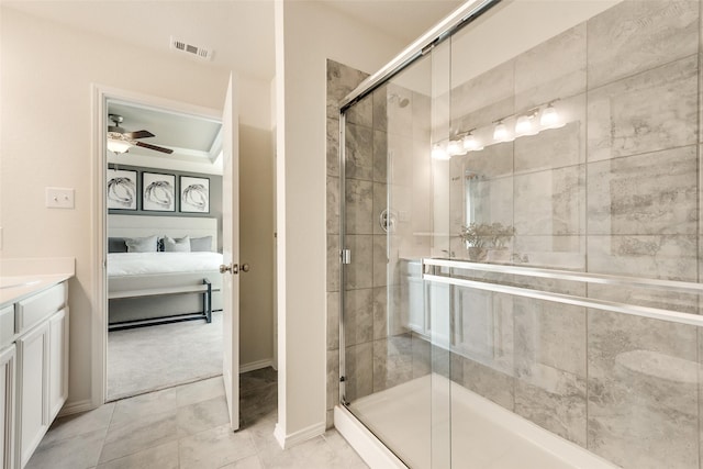 ensuite bathroom with vanity, a ceiling fan, a shower stall, and visible vents