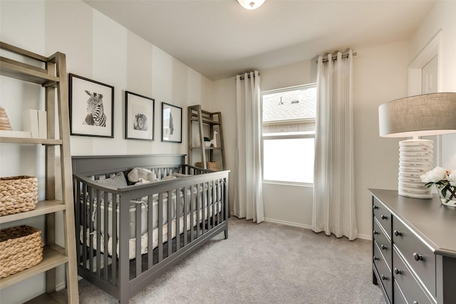 bedroom with a crib, baseboards, and light colored carpet