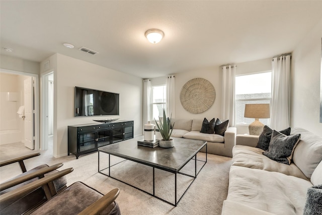 living area with visible vents, light carpet, and a healthy amount of sunlight