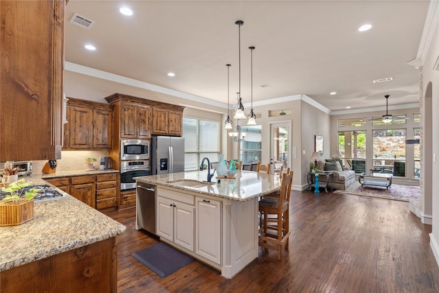 5916 River Highlands Dr, Mckinney, TX 75070 - kitchen with appliances with stainless steel finishes, a sink, light stone countertops, brown cabinets, and ceiling fan