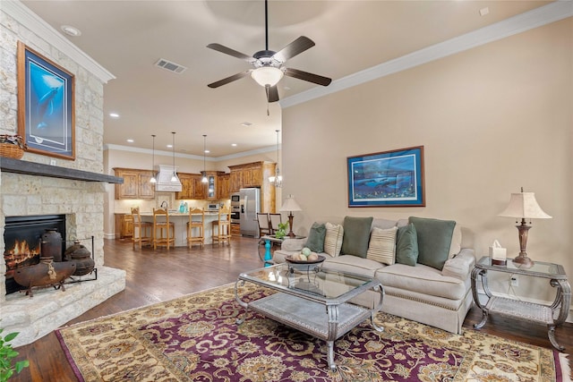 5916 River Highlands Dr, Mckinney, TX 75070 - living room with ceiling fan, crown molding, dark wood finished floors, a stone fireplace, and recessed lighting